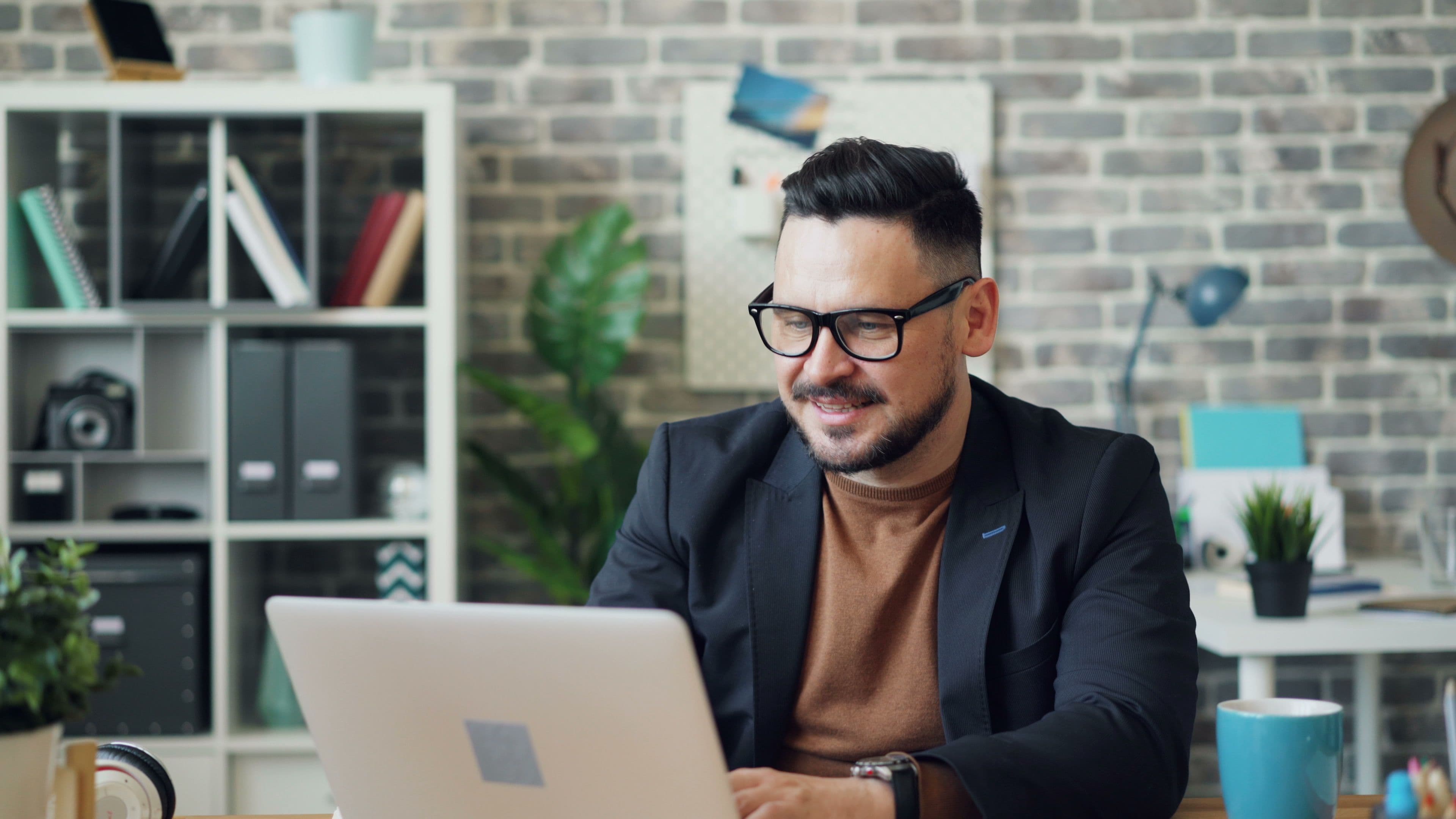 Mannelijke praktijkmedewerker werkt aan een laptop