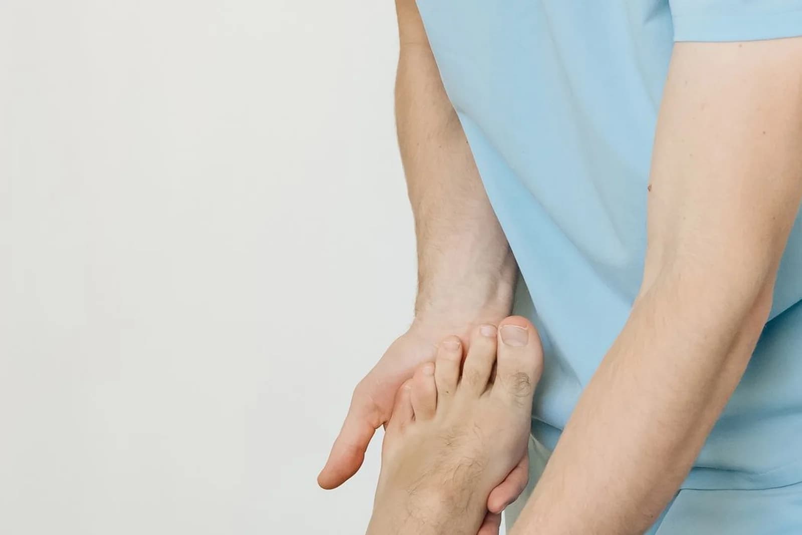 Mannelijke behandelaar onderzoekt de voet van een mannelijke patiënt