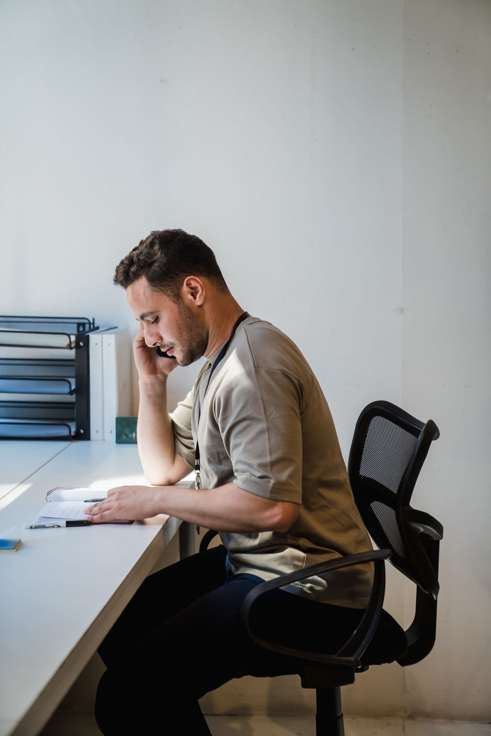 Mannelijke praktijkmedewerker helpt telefonisch met een planningsvraag